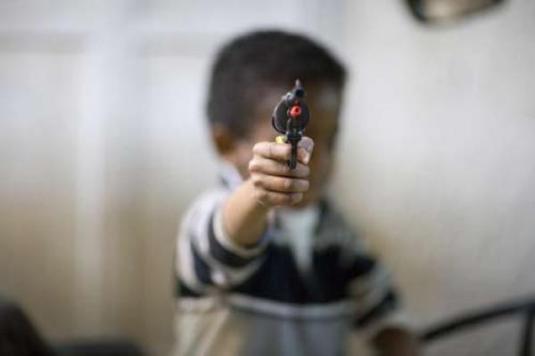 niño con un arma de juguete